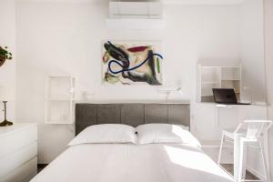Un dormitorio con una cama con un cuadro en la pared. en Pomodoro House, en Milán