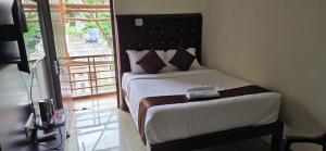 een slaapkamer met een bed in een kamer met een balkon bij Hotel AMR Residency in Tiruchirappalli