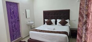 een slaapkamer met een groot bed en een wastafel bij Hotel AMR Residency in Tiruchirappalli