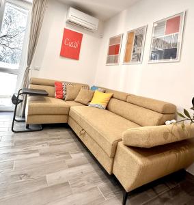 a living room with a couch and a sign on the wall at Pomodoro House - Luminoso appartamento vicino Linate, Duomo, Fabrique, Unipol Dome in Milan