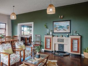 a living room with green walls and a fireplace at Harewood Lodge in East London
