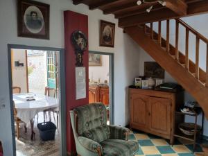 ein Wohnzimmer mit einem Stuhl, einem Tisch und einer Treppe in der Unterkunft Maison Julie in Woignarue