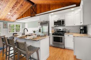 a kitchen with white appliances and wooden ceilings at Tranquil Pond-View Escape in Dennis in Dennis
