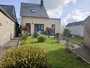 ein weißes Haus mit einem Garten mit Büschen in der Unterkunft Maison Julie in Woignarue