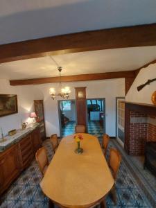 ein Esszimmer mit Tisch und Kamin in der Unterkunft Maison Julie in Woignarue