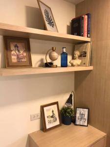 Un estante con algunos cuadros y libros. en Narada Residence, en Pak Kret 17 fotos más
