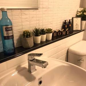 Un lavabo de baño con una botella de agua y plantas. en Narada Residence, en Pak Kret