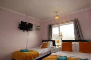 ein Schlafzimmer mit zwei Betten und einem Fenster in der Unterkunft Milton House Chesterfield By Smart Corporate Stays in Chesterfield