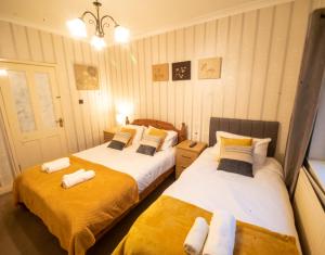 2 Betten in einem gelb-weißen Zimmer in der Unterkunft Milton House Chesterfield By Smart Corporate Stays in Chesterfield