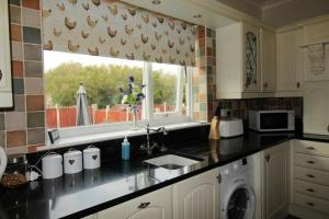 eine Küche mit Spüle und Fenster in der Unterkunft Milton House Chesterfield By Smart Corporate Stays in Chesterfield