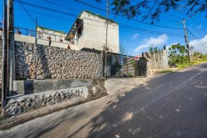 an empty street in front of a stone wall at Jiya Villa Uluwatu - Panoramic Terraces with Stunning Views, Luxury Service and Entertainment in Uluwatu +141 photos