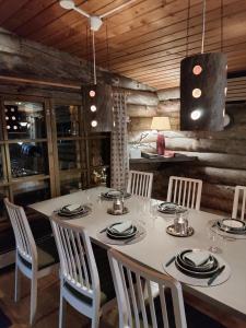 a dining room with a white table and chairs at Hillavilla in the shores of lake Inari in Inari