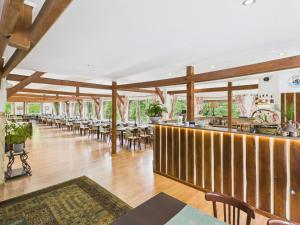 a dining room with tables and chairs and a bar at Kompleks Wypoczynkowo-Konferencyjny Mazur-Syrenka in Krutyń