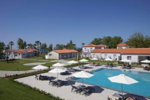 a pool at a resort with umbrellas and chairs at Paleros Beach Resort in Paleros