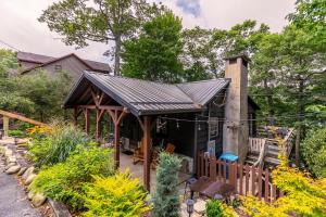 a house with a roof over a garden at Sky Laurel Cottage in Blowing Rock