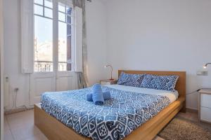 Un dormitorio con una cama con un osito de peluche azul encima. en Apartamento Sant Gervasi, en Barcelona