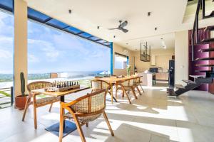ein Esszimmer mit Tisch und Stühlen und einem großen Fenster in der Unterkunft Jiya Villa Uluwatu - Panoramic Terraces with Stunning Views, Luxury Service and Entertainment in Uluwatu