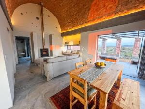 a living room with a table and a couch at Windvogels - Off Grid in Goedgeloof +42 photos