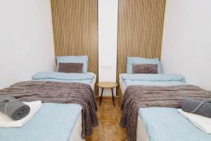 a room with two beds with blankets and pillows at Santomera 1st Line in Torrevieja +41 photos