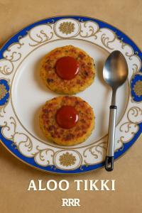 a white plate with two pizzas and a spoon at Ranibagh Riverview Retreat in Kāthgodām