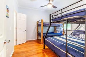 Un dormitorio con dos literas y un ventilador de techo. en Driftwood Sands Retreat, en Montague