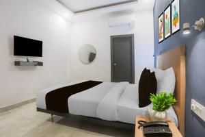 um quarto com uma cama, uma escrivaninha e uma televisão em Hotel O Vivek inn Palace em Prayagraj