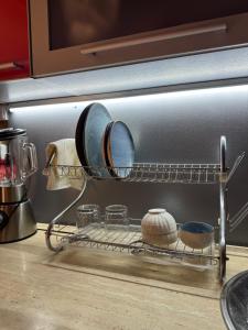 un estante en una cocina con platos y sartenes en Cozy, en Bishkek 10 fotos más