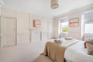 a white bedroom with a bed and a window at Beautiful 1-Bed Flat with High Ceilings in Bath