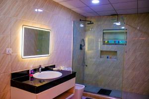 a bathroom with a sink and a shower at The Glass Residence Jabi in Abuja +25 photos