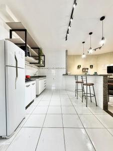 Il comprend une cuisine avec des appareils électroménagers blancs et du carrelage blanc. dans l'établissement Apartamento Premium Cama Queen Ar Cond centro cidade, à Formosa