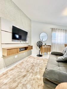 un salon avec un canapé et une télévision à écran plat dans l'établissement Apartamento Premium Cama Queen Ar Cond centro cidade, à Formosa