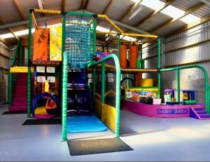 a play room with a playground with a slide at Loch View 30 in Stranraer
