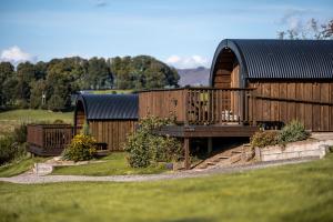 a wooden cabin with a table and a bench at Luxury Glamping Pods - The Heft & The Hirsel in Glasgow +23 photos