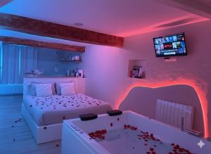 a bedroom with a bed and a tub with blood on the floor at À la folie - Loft & Spa in Montrevault