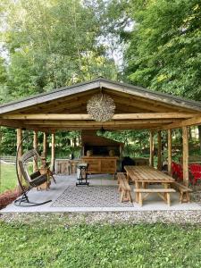 a wooden pavilion with a picnic table and benches at Golden Valley Retreat in Hersey