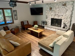 a living room with a couch and a stone fireplace at Golden Valley Retreat in Hersey