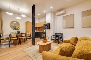 BEAUFITUL APMT - AC -2BR-6P- NOTRE DAME في باريس: غرفة معيشة ومطبخ مع أريكة وطاولة