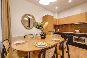 BEAUFITUL APMT - AC -2BR-6P- NOTRE DAME في باريس: غرفة طعام مع طاولة وكراسي خشبية +7 صور