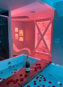 a bottle of wine sitting on a table in a bath tub at À la folie - Loft & Spa in Montrevault