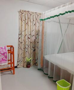 a room with a bed and a curtain and a chair at Dream Image in Nikawatawana