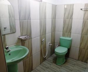 a bathroom with a green toilet and a sink at Dream Image in Nikawatawana