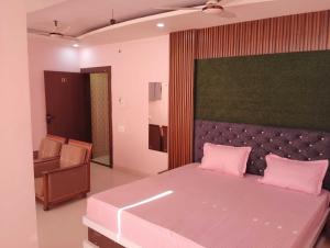 a bedroom with a large bed with pink pillows at Palette Hotel and Resort Kankarbagh Main Road Formerly Aalcajars Inn in Bankipur +18 photos