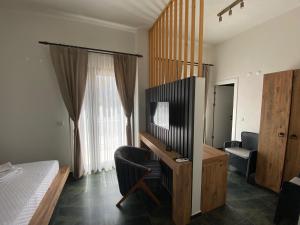 a bedroom with a bed and a desk with a television at olives tree in Datca