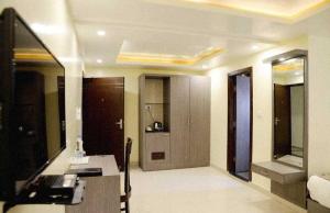a living room with a desk and a television at Palette Hotel and Resort Kankarbagh Main Road Formerly Aalcajars Inn in Bankipur