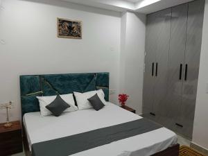 a bedroom with a large white bed and a cabinet at Collection O South City 1 Arcadia in Gurgaon
