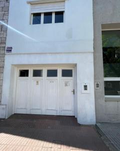 a white building with two white doors on it at Centro de Rafaela Para 2 Personas in Rafaela