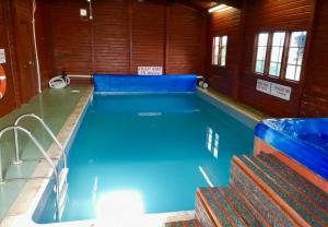 a large swimming pool with blue water in a building at Loch View 30 in Stranraer