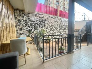 a room with a balcony with chairs and a wall at Maison Meublé de 3 CH Essos in Yaoundé