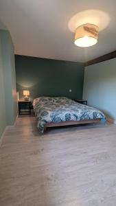 a bedroom with a bed and a green wall at Gîte Les Bougrines - Marais in Fontaines