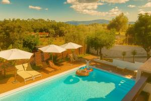 AlgaçaQuinta do Chafariz的一座房子里一个带椅子和遮阳伞的游泳池